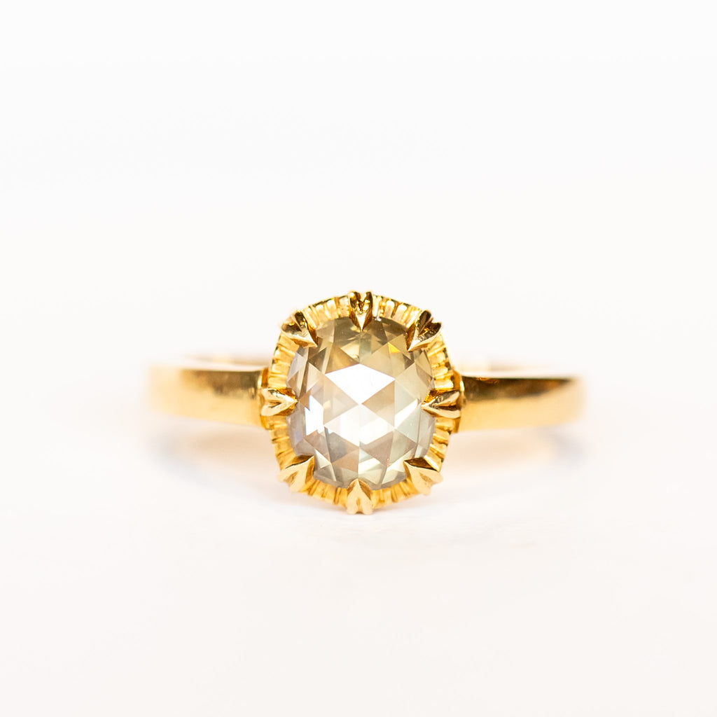 A rose cut cushion shaped diamond solitaire ring, set in an 8-prong, 18 karat yellow gold mounting.