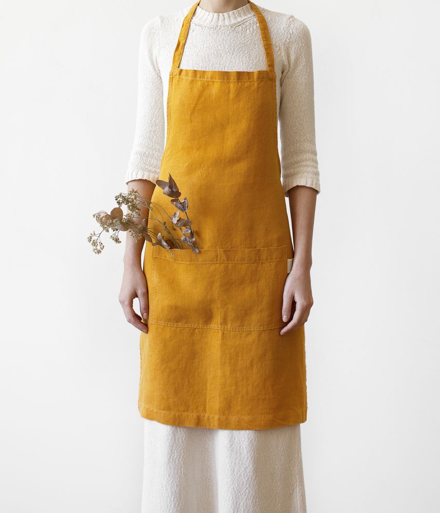 Linen Tales yellow apron on model, front view