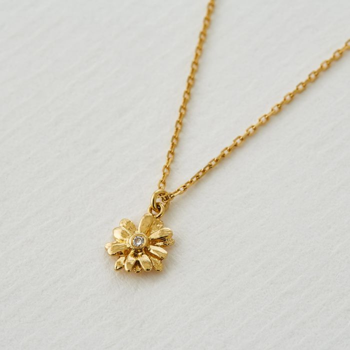 Alex Monroe gold necklace with daisy pendant and diamond, front view