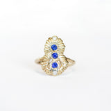 Top view of a Communion by Joy ring, hand carved from 14 karat yellow gold, it is set with three deep blue round sapphires and two white diamonds. 
