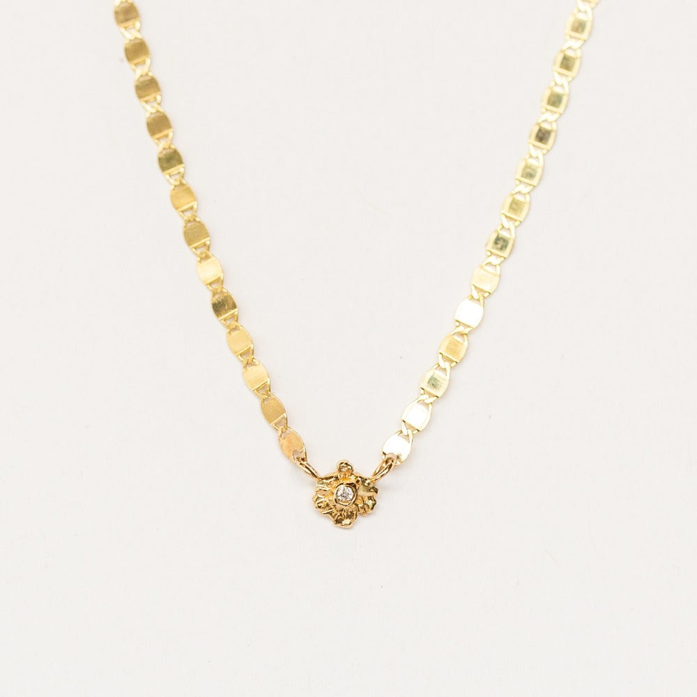 A flattened link gold chain necklace set with a tiny diamond from Communion by Joy.