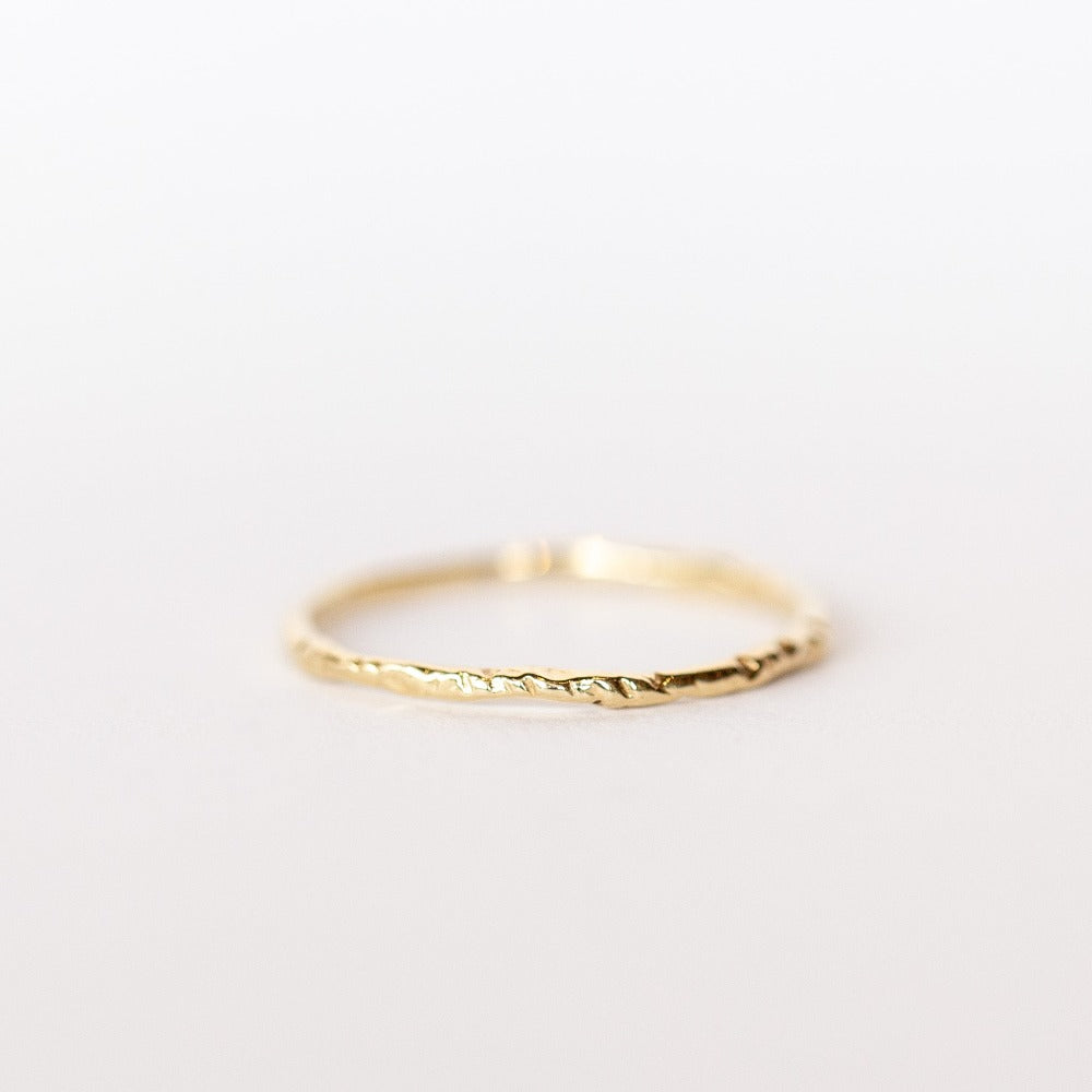 A thin, hand carved yellow gold band from Communion by Joy.
