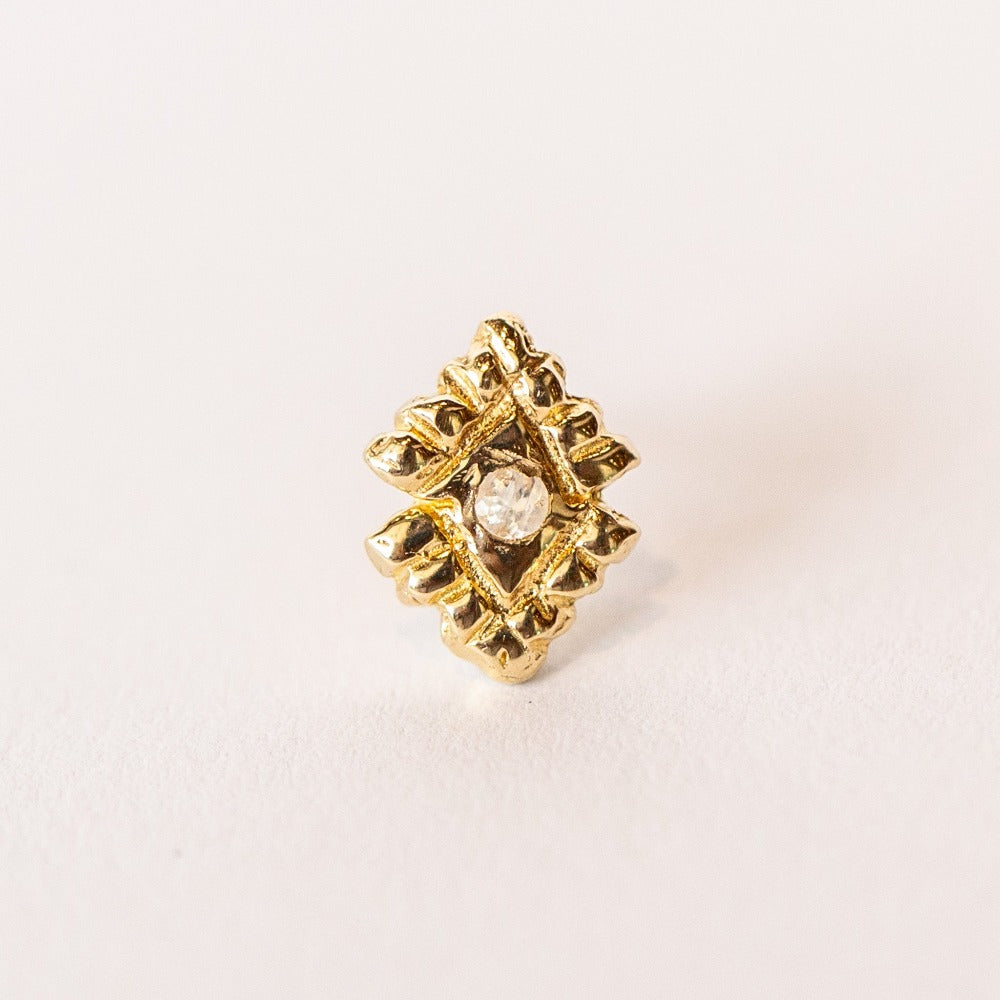 A pair of hand carved, diamond shaped yellow gold stud earrings from Communion by Joy, featuring small white moonstones.