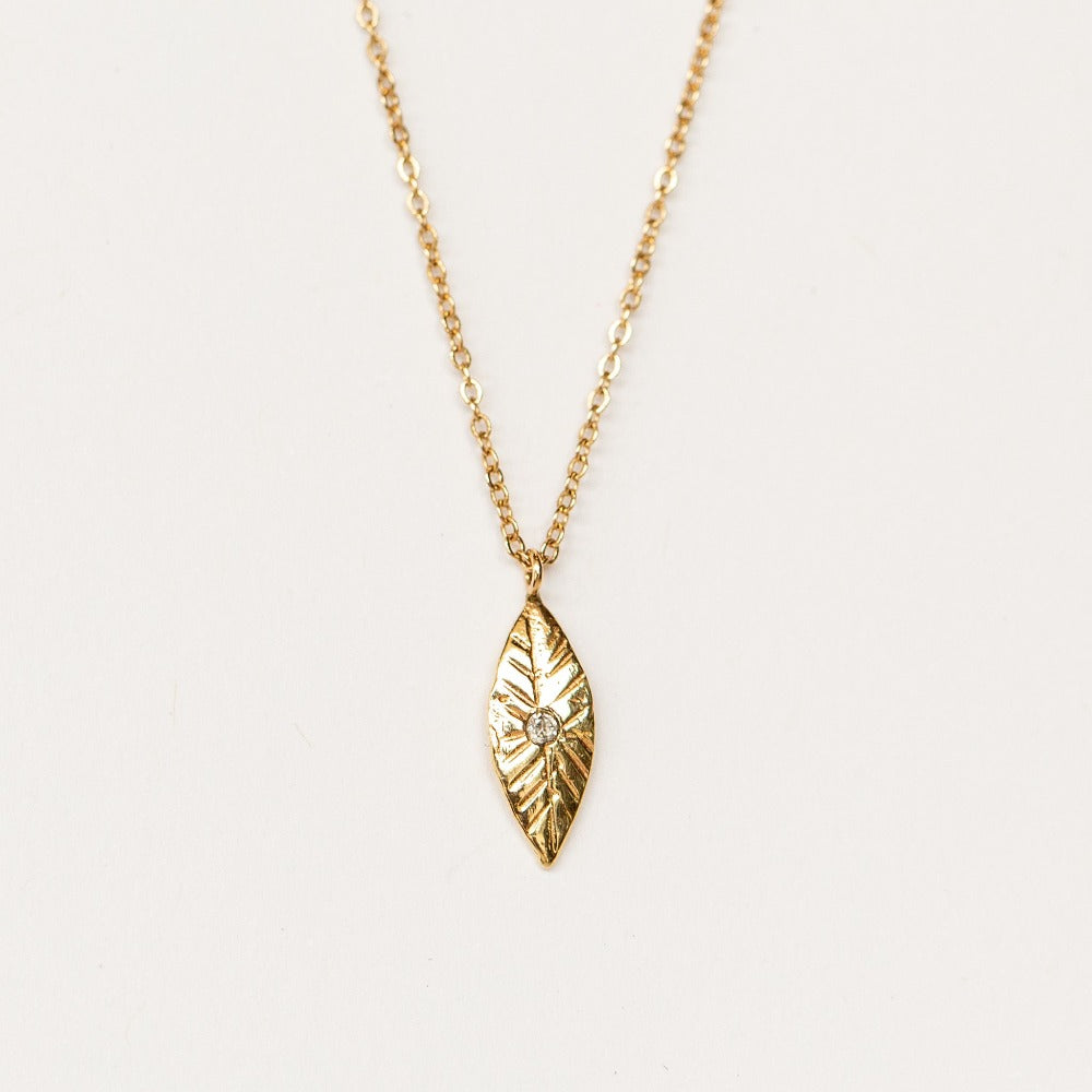 A hand carved petal shaped pendant with diamond from Communion by Joy.
