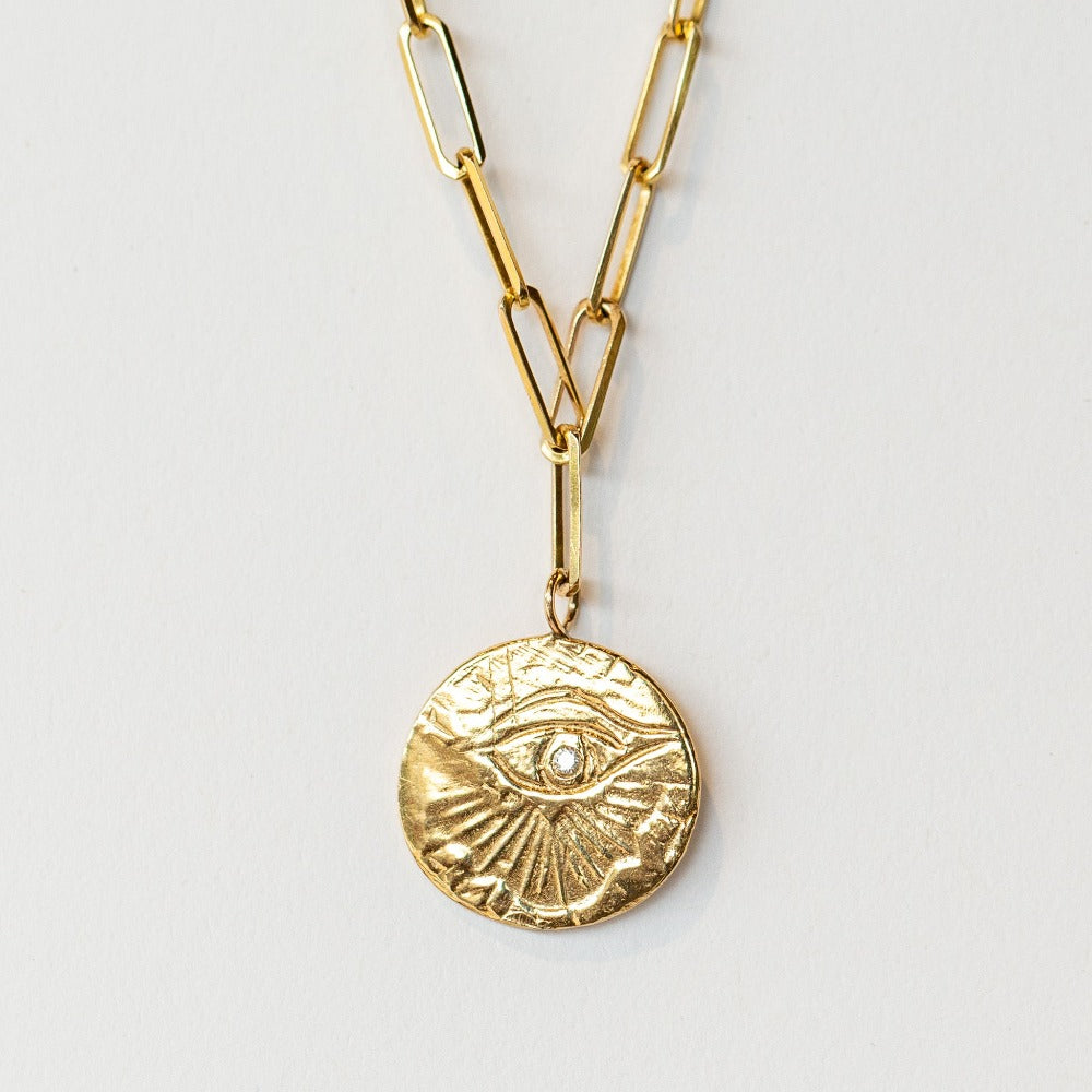 In this Communion by Joy bracelet, a hand-carved eye of love medallion hangs from an on-trend paperclip chain bracelet in 14 karat yellow gold. It's set with a single diamond.