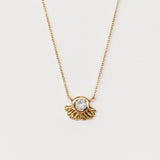 A carved gold pendant set with rainbow moonstone from Communion by Joy.
