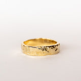 A hand carved wide yellow gold band from Communion by Joy.