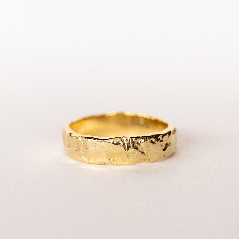 A hand carved wide yellow gold band from Communion by Joy.