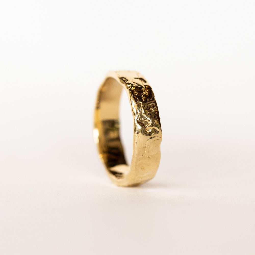 A hand carved wide yellow gold band from Communion by Joy.