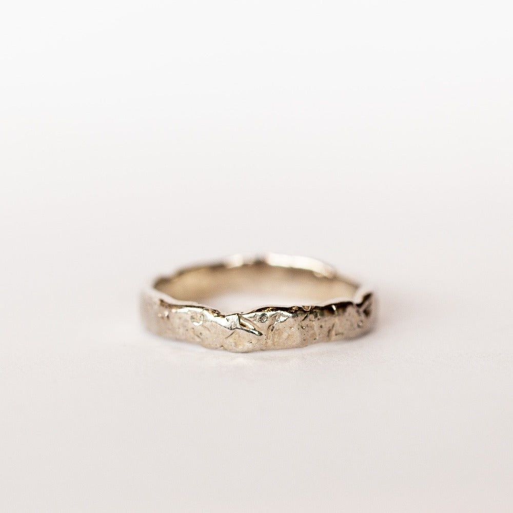 A hand carved 4mm width wedding band from Communion by Joy.
