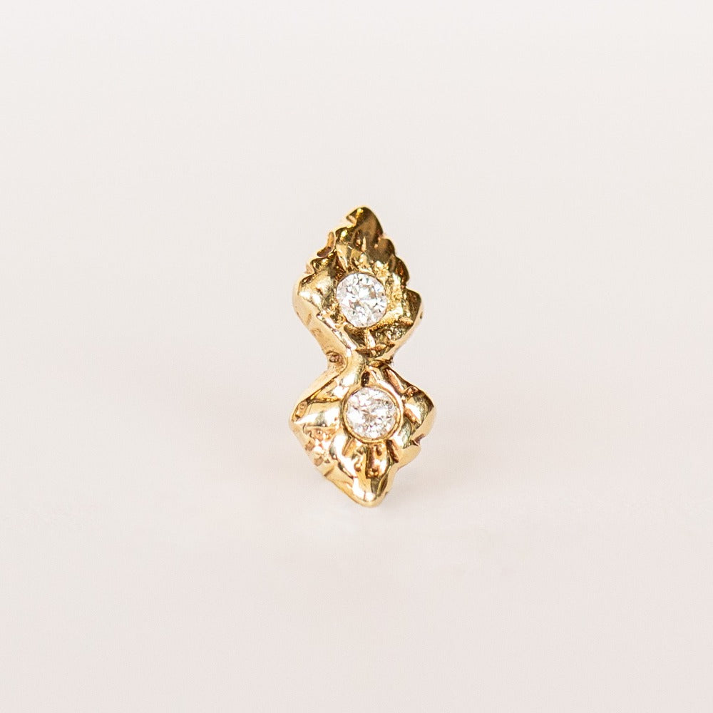 A pair of hand carved yellow gold stud earrings set with four small diamonds from Communion by Joy.