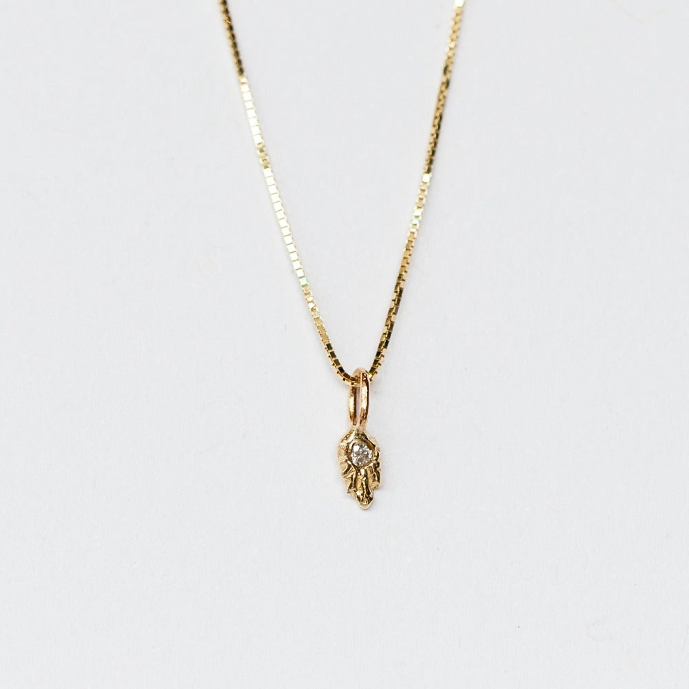 A dainty, carved gold diamond pendant from Communion by Joy.