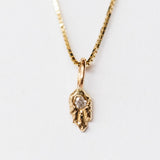 A dainty, carved gold diamond pendant from Communion by Joy.