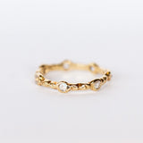 Side view of Communion by Joy eternity band, seven petite faceted moonstone gems are set in hand carved details.