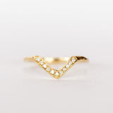 A yellow gold contour band from Communion by Joy, in a triangular peaked design, set with tiny white pave diamonds.