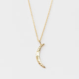 A carved gold crescent moon pendant from Communion by Joy.