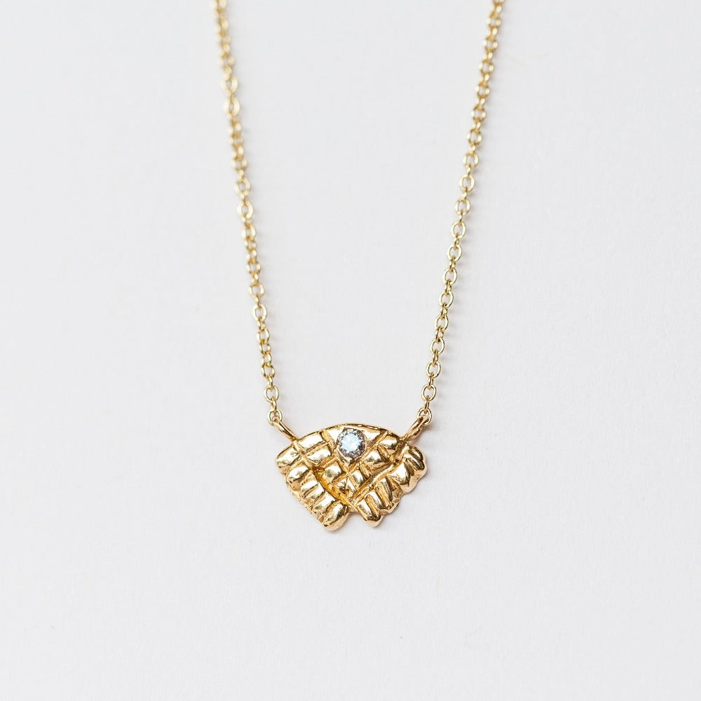 Small carved yellow gold necklace with a tiny diamond from Communion by Joy.