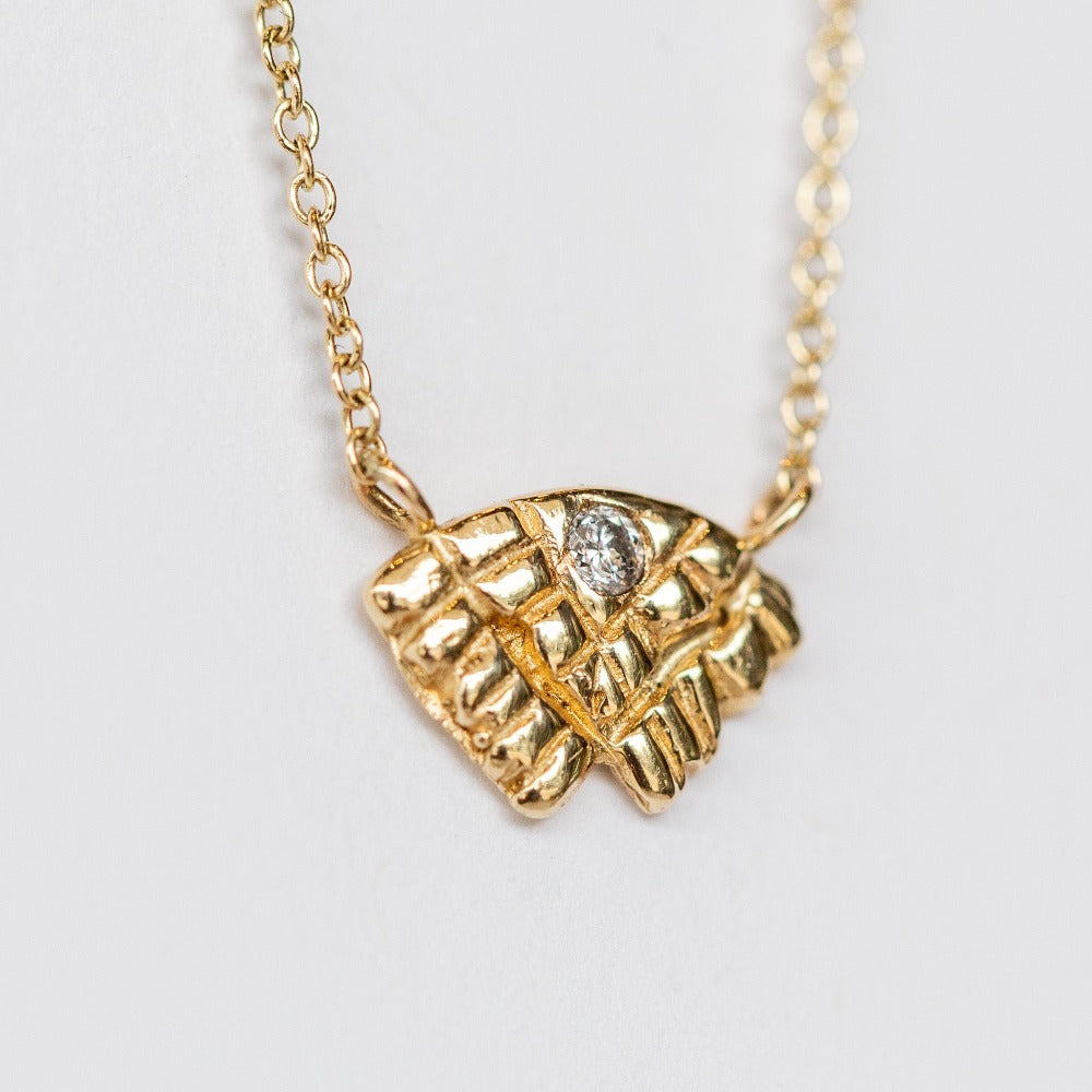 Small carved yellow gold necklace with a tiny diamond from Communion by Joy.