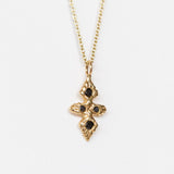 A hand carved yellow gold cross necklace set with black diamonds from Communion by Joy.