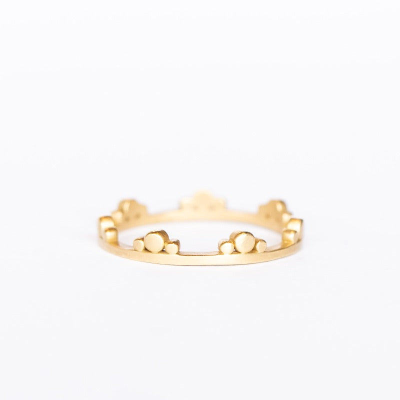 A dainty gold ring with dot trios along one side from Ananda Khalsa. 