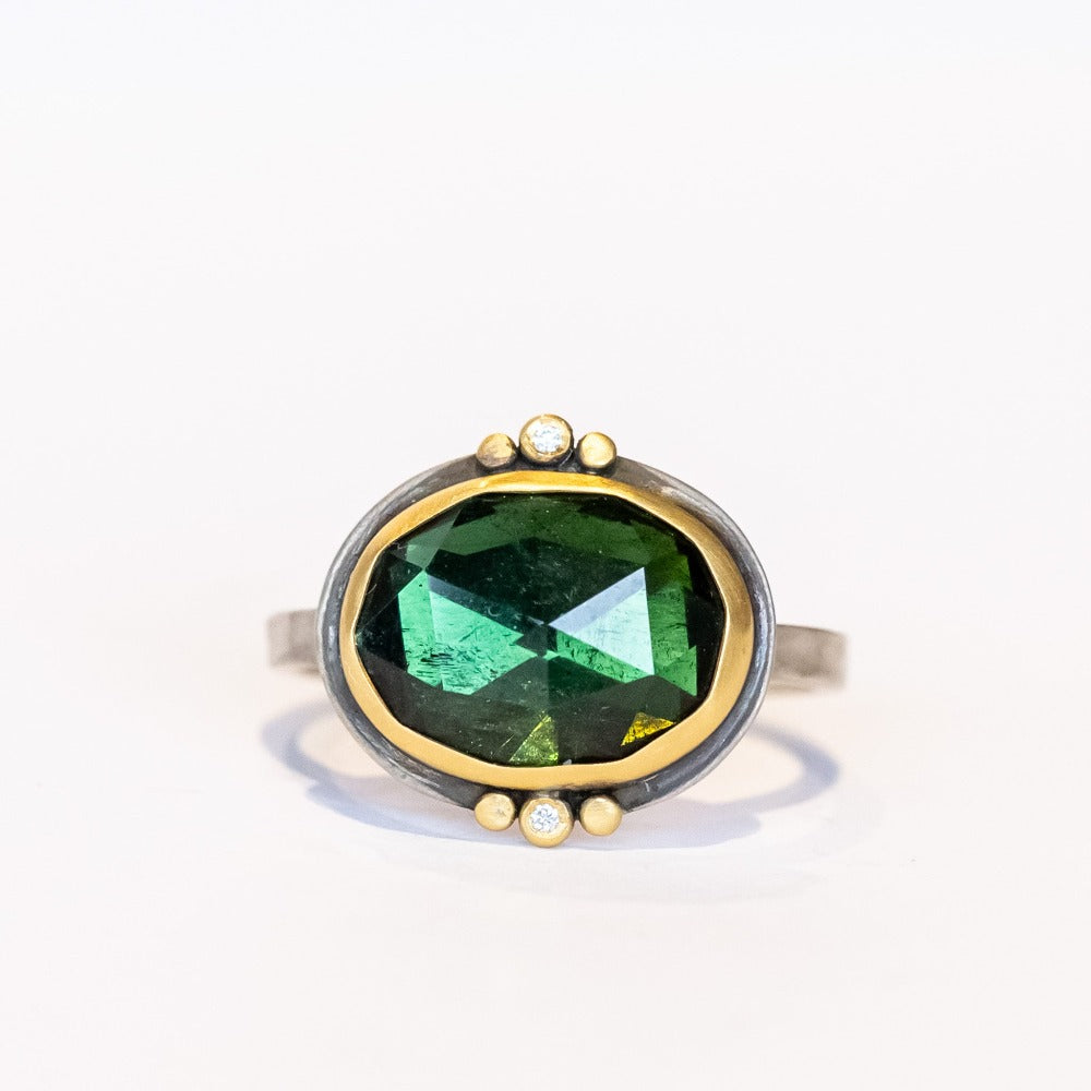 This one-of-a-kind Ananda Khalsa gemstone ring features a deep green oval rose cut tourmaline accented by tiny diamonds and 22k yellow gold dot accents set in a sterling silver ring.