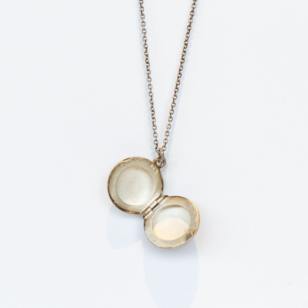 The inside of a round silver locket.