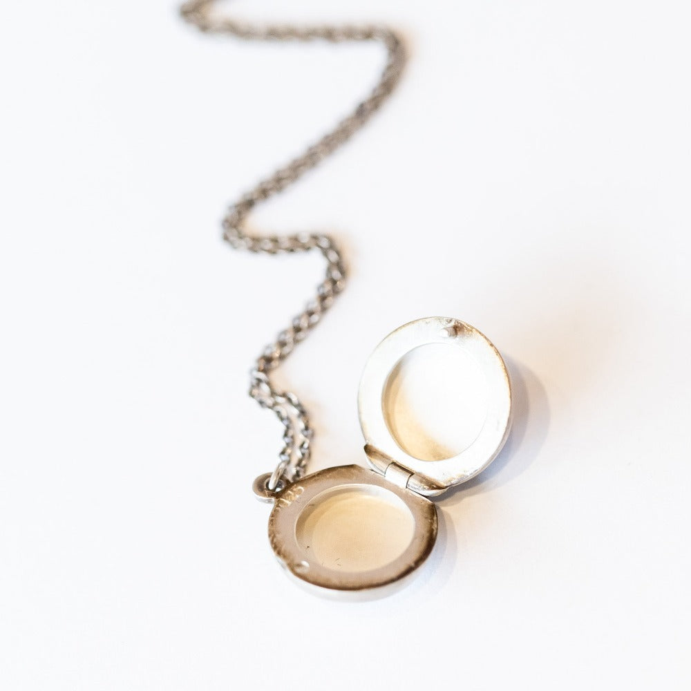 The inside of a round silver locket.