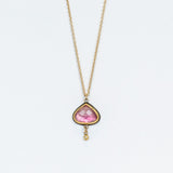 A yellow gold chain necklace with a wide teardrop, rose cut pink tourmaline in a 22k yellow gold bezel backed by oxidized sterling silver. A tiny bezel-set diamond charm dangles freely from the base.