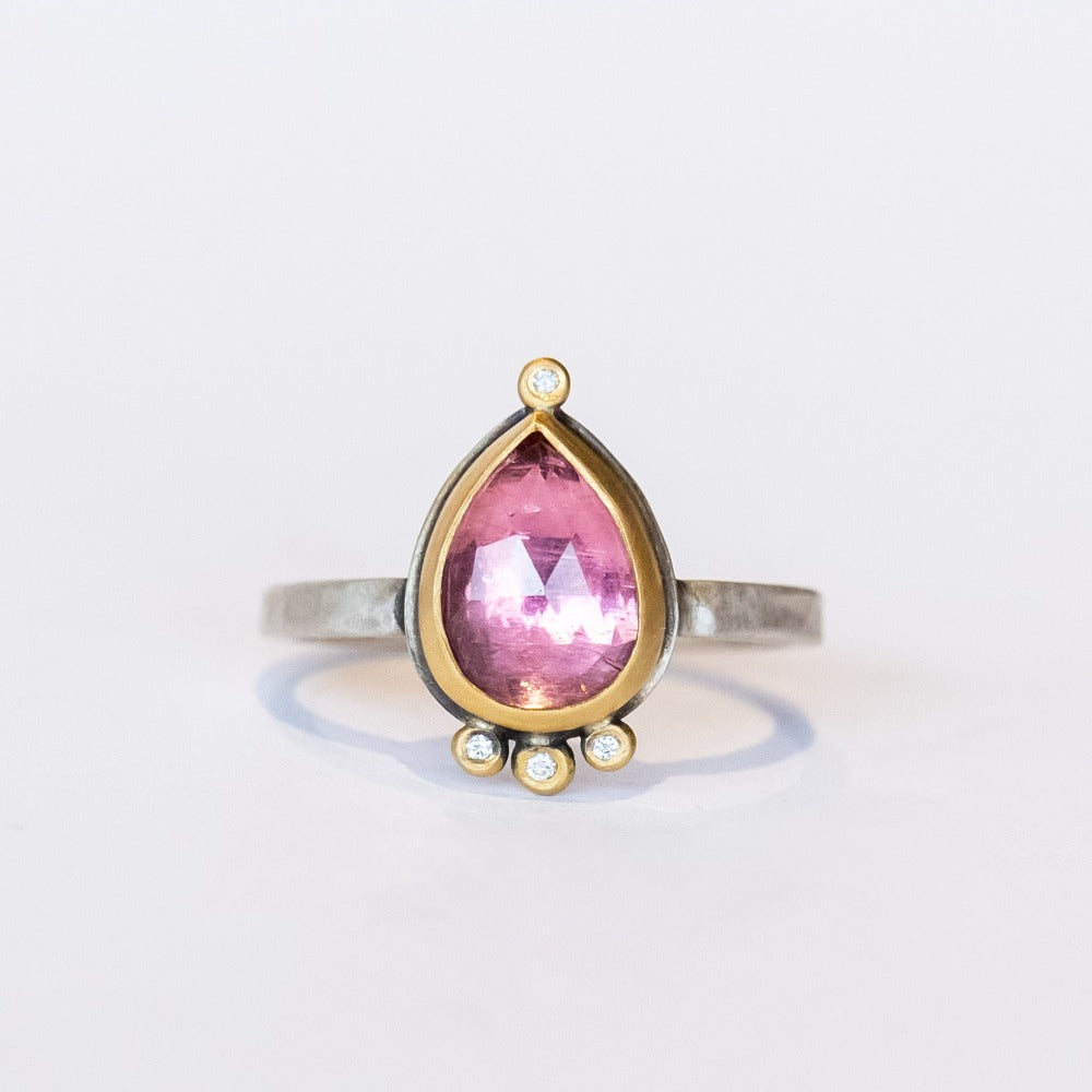 A smoky pink tourmaline in a teardrop shape is bezel set in yellow gold, with four diamond accents on this silver Ananda Khalsa ring.