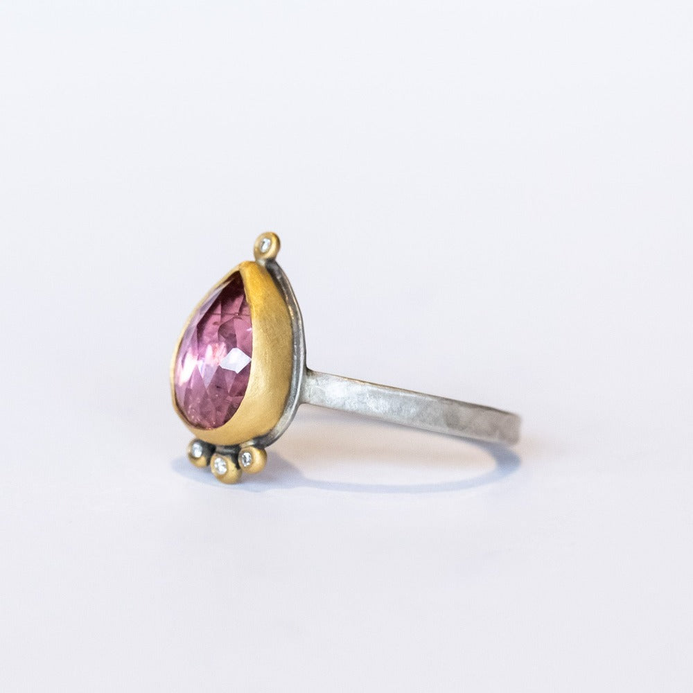 A smoky pink tourmaline in a teardrop shape is bezel set in yellow gold, with four diamond accents on this silver Ananda Khalsa ring.