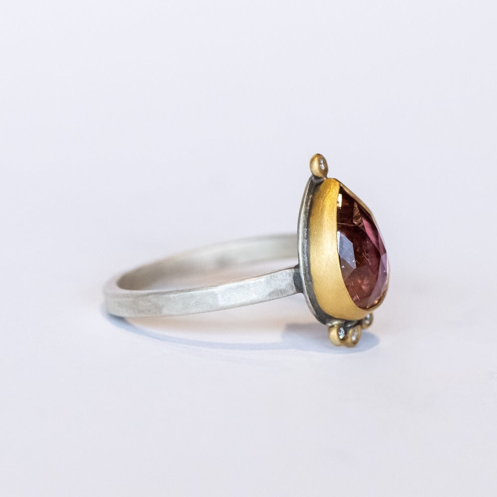 A smoky pink tourmaline in a teardrop shape is bezel set in yellow gold, with four diamond accents on this silver Ananda Khalsa ring.