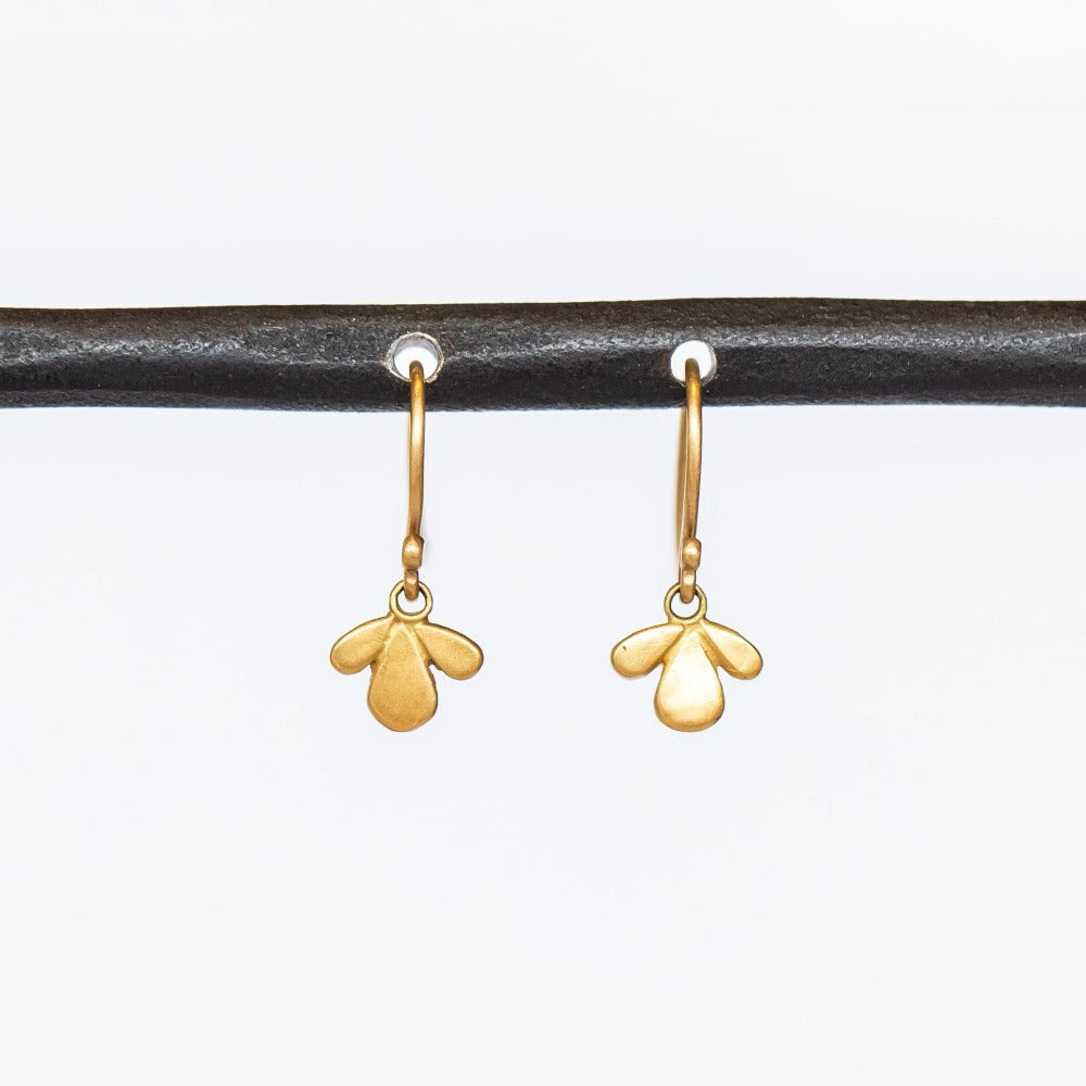 Tiny gold, leaf-shaped drop earrings.