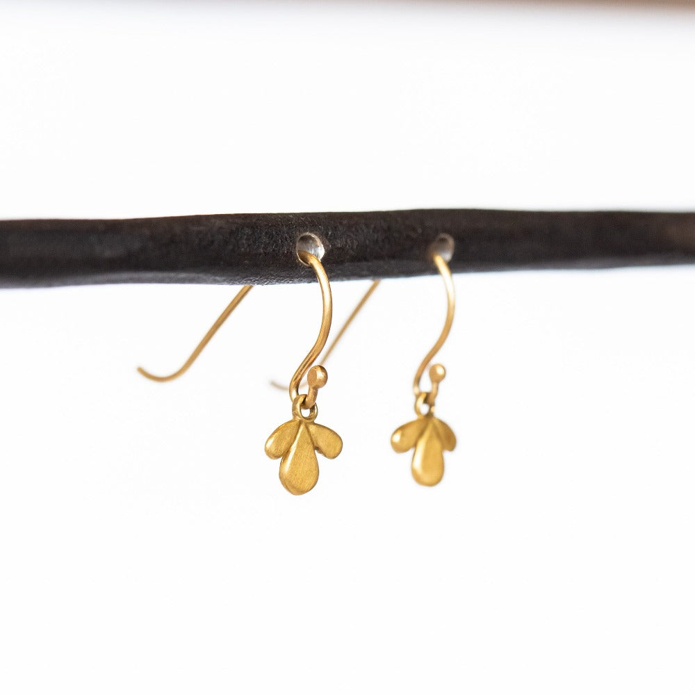 Tiny gold, leaf-shaped drop earrings.