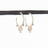A pair of petite, brushed silver hoop earrings that feature flat dot accents.