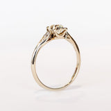 A diamond engagement ring with an old mine cushion cut center stone, raised cathedral shoulders with accent diamonds, in 18k white gold.