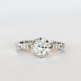 A platinum engagement ring with a prong set old European cut diamond, cathedral shoulders, and three accent diamonds on each shoulder.