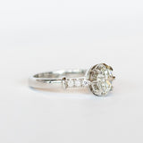 A platinum engagement ring with a prong set old European cut diamond, cathedral shoulders, and three accent diamonds on each shoulder.
