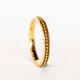 A rose gold wedding band with beaded detail all the way around and oxidized surface for contrast.