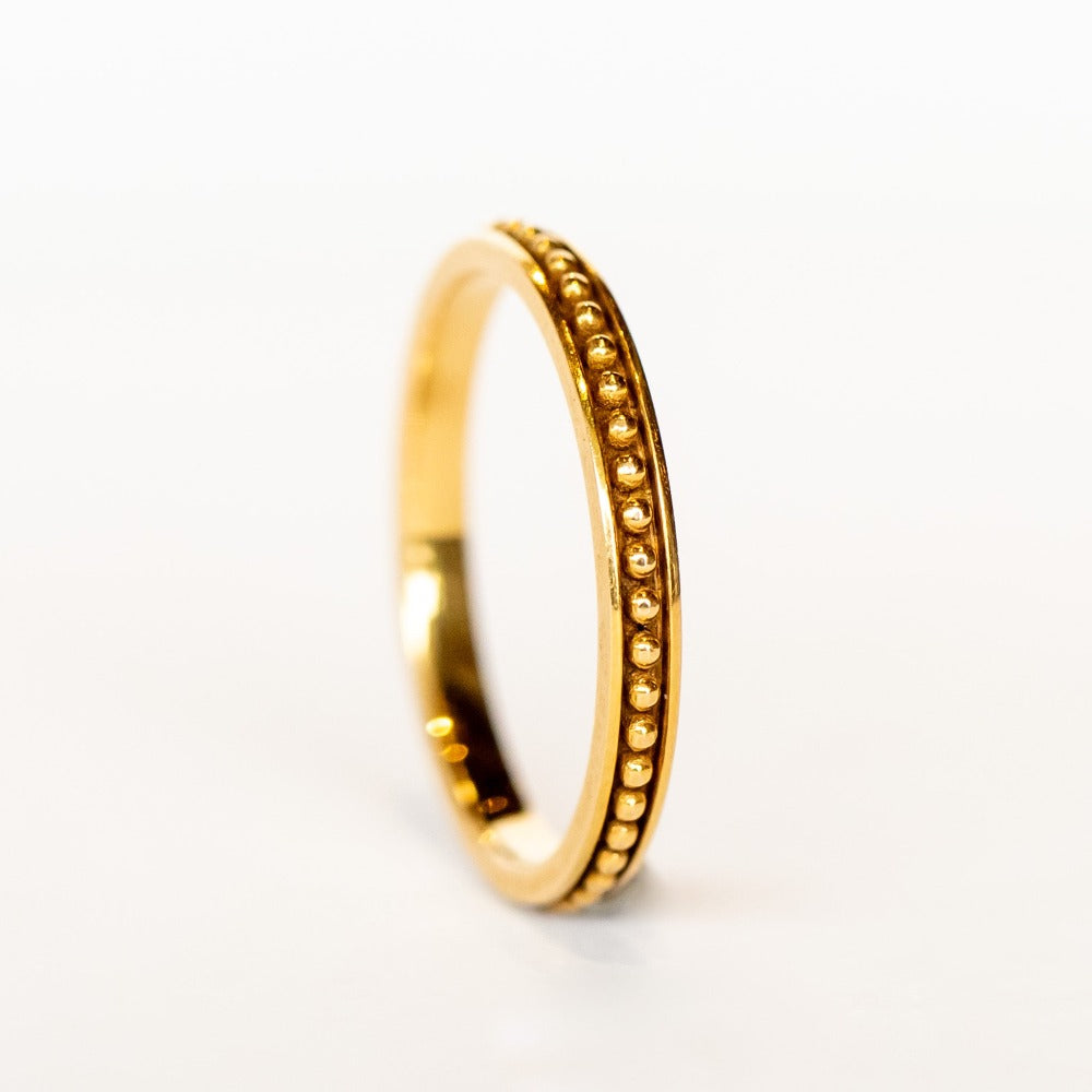 A rose gold wedding band with beaded detail all the way around and oxidized surface for contrast.
