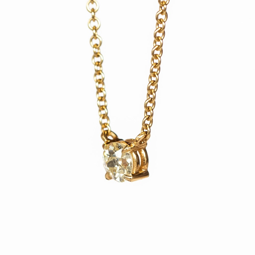 A prong set old mine cut diamond station pendant on a yellow gold cable chain necklace.