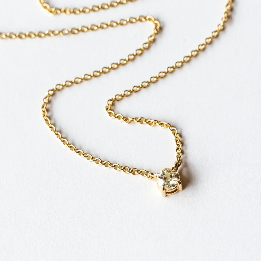 A prong set old mine cut diamond station pendant on a yellow gold cable chain necklace.