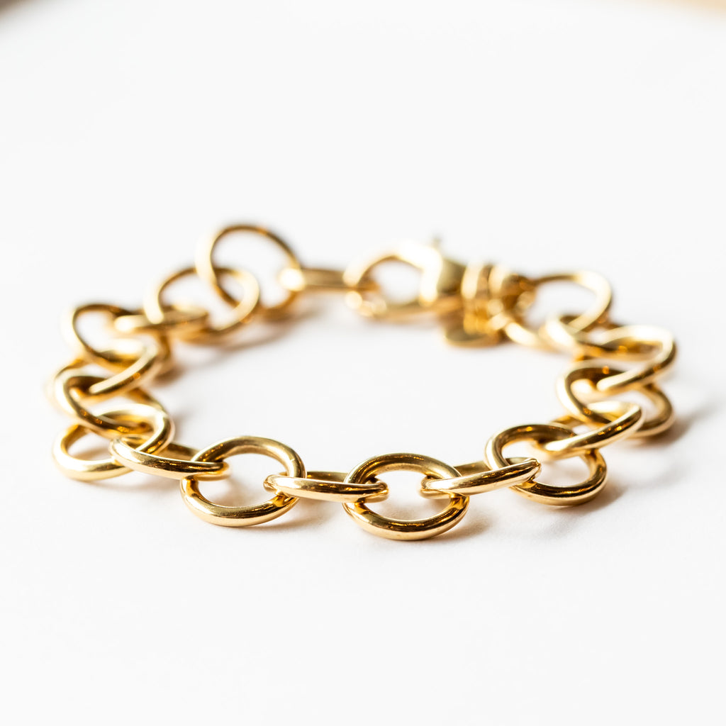 A gold chain bracelet made up of large round links.