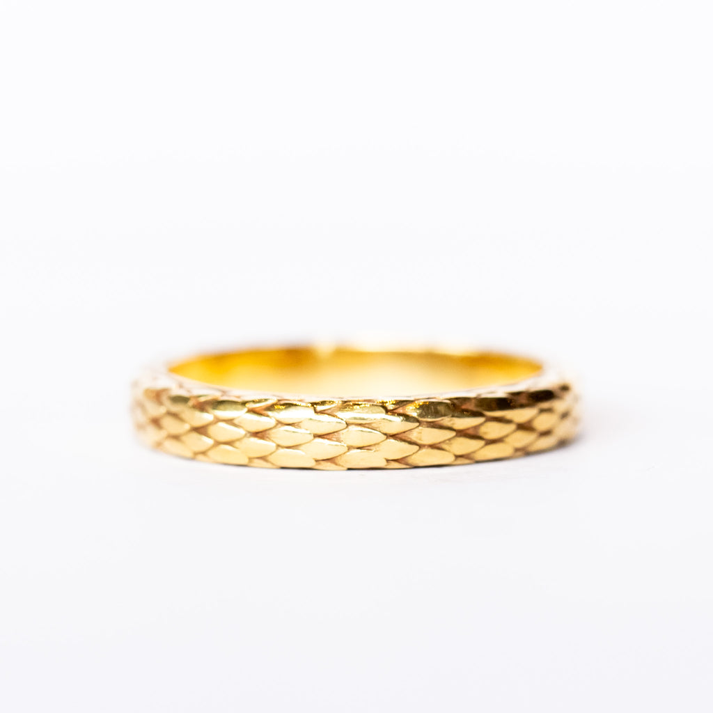 A wide yellow gold band with snakeskin scale pattern all the way around.