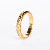 A wide yellow gold band with snakeskin scale pattern all the way around.