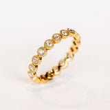 A yellow gold and diamond eternity band with rose cut round diamonds bezel set with milgrain edges.