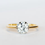 A yellow gold diamond solitaire engagement ring with an old European cut diamond set in platinum prongs.