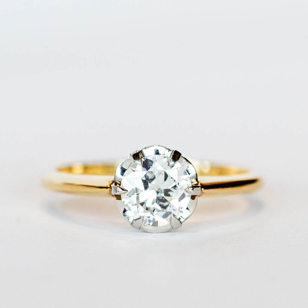 A yellow gold diamond solitaire engagement ring with an old European cut diamond set in platinum prongs.