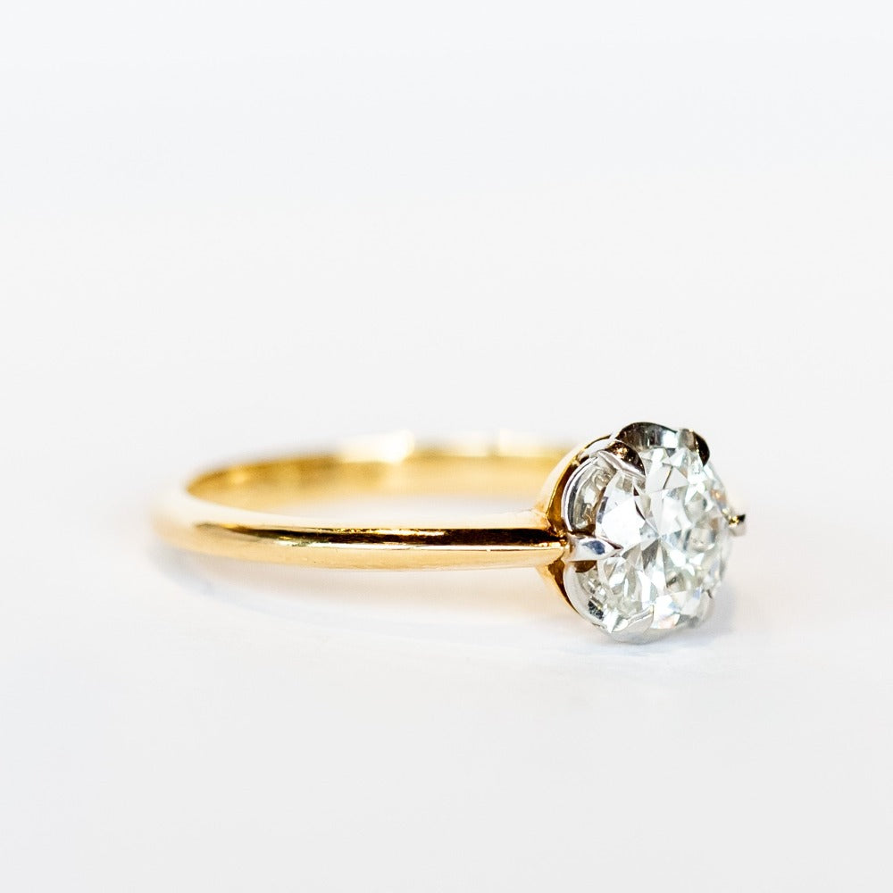 A yellow gold diamond solitaire engagement ring with an old European cut diamond set in platinum prongs.