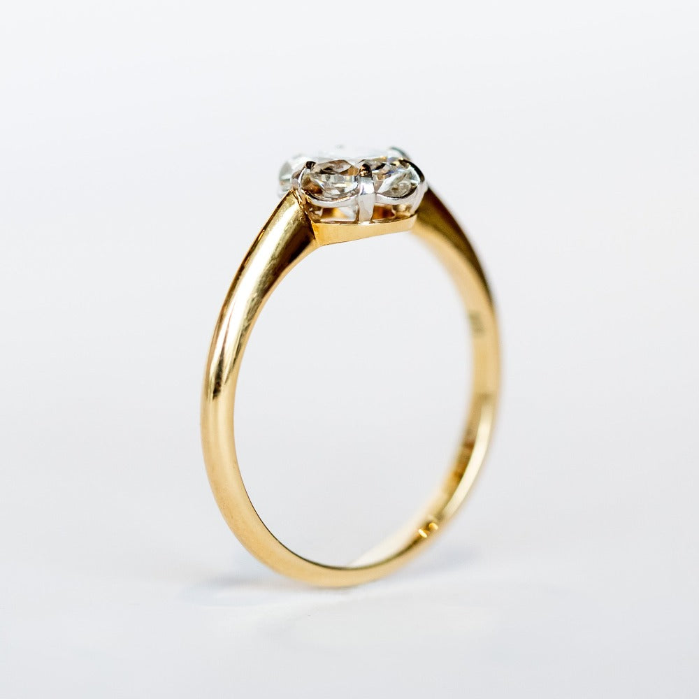 A yellow gold diamond solitaire engagement ring with an old European cut diamond set in platinum prongs.