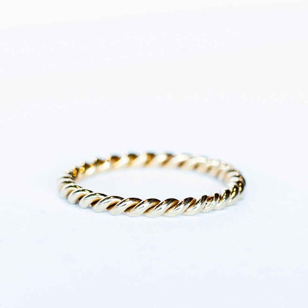 A white gold wedding band made up of two twisted strands with a polished finish.